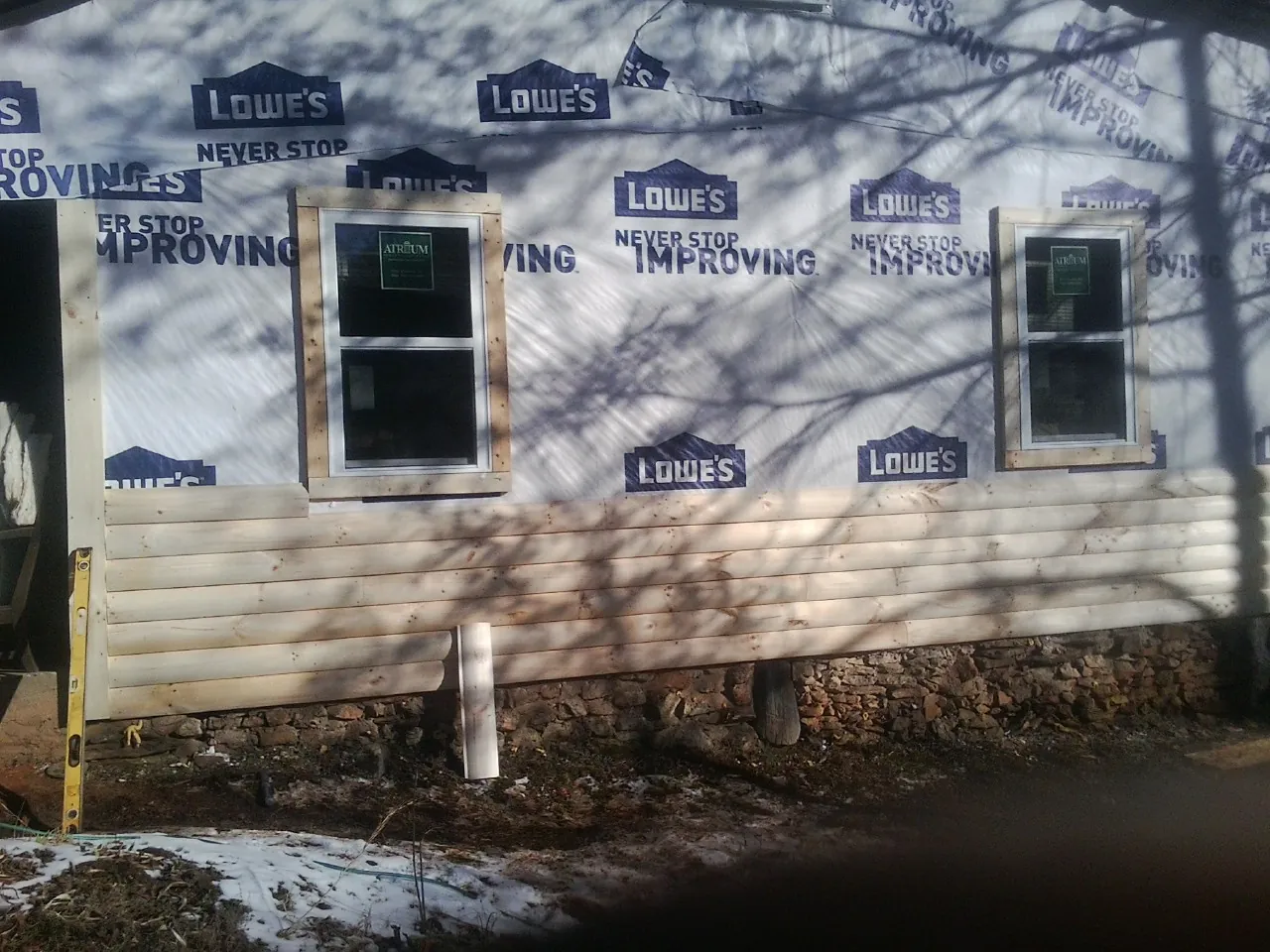House wrap and new log siding going up on an exterior wall in Mc Adenville