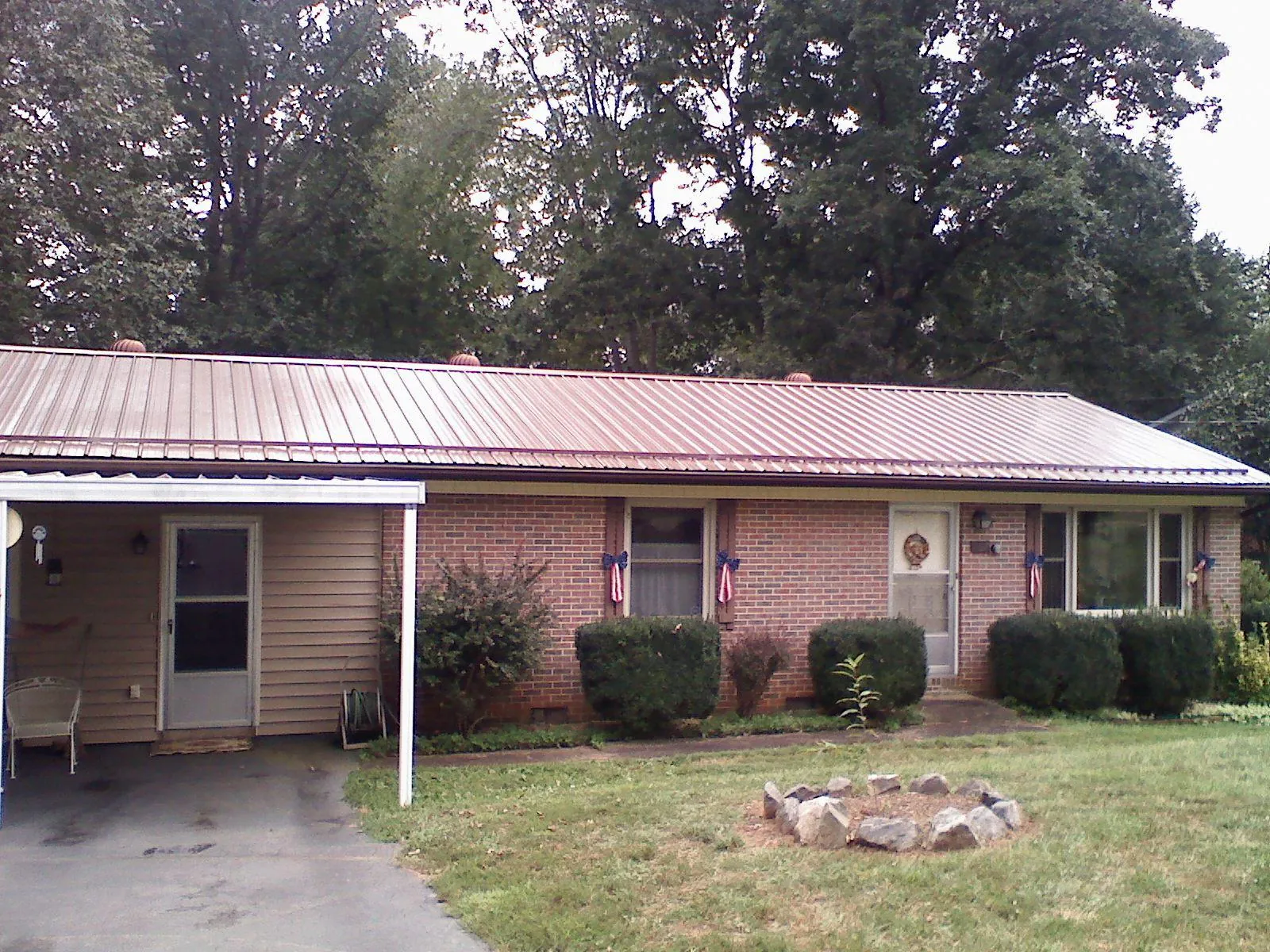 Bronze metal roof and carport on a brick ranch home — Roof Repair work by our crew in Mc Adenville